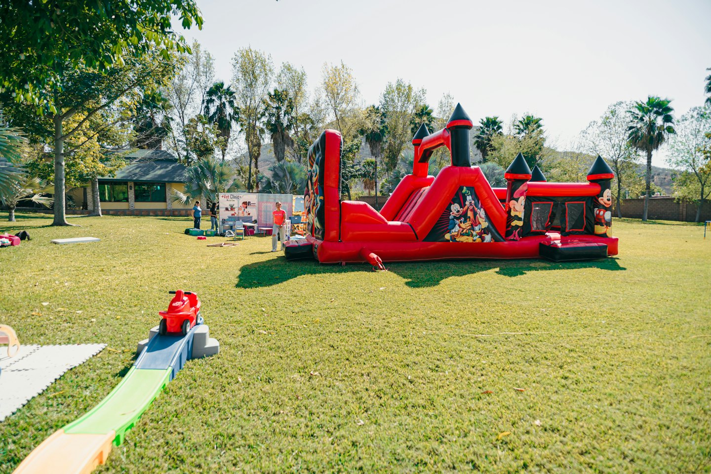 Children play in an inflatable bounce house on a grassy lawn.